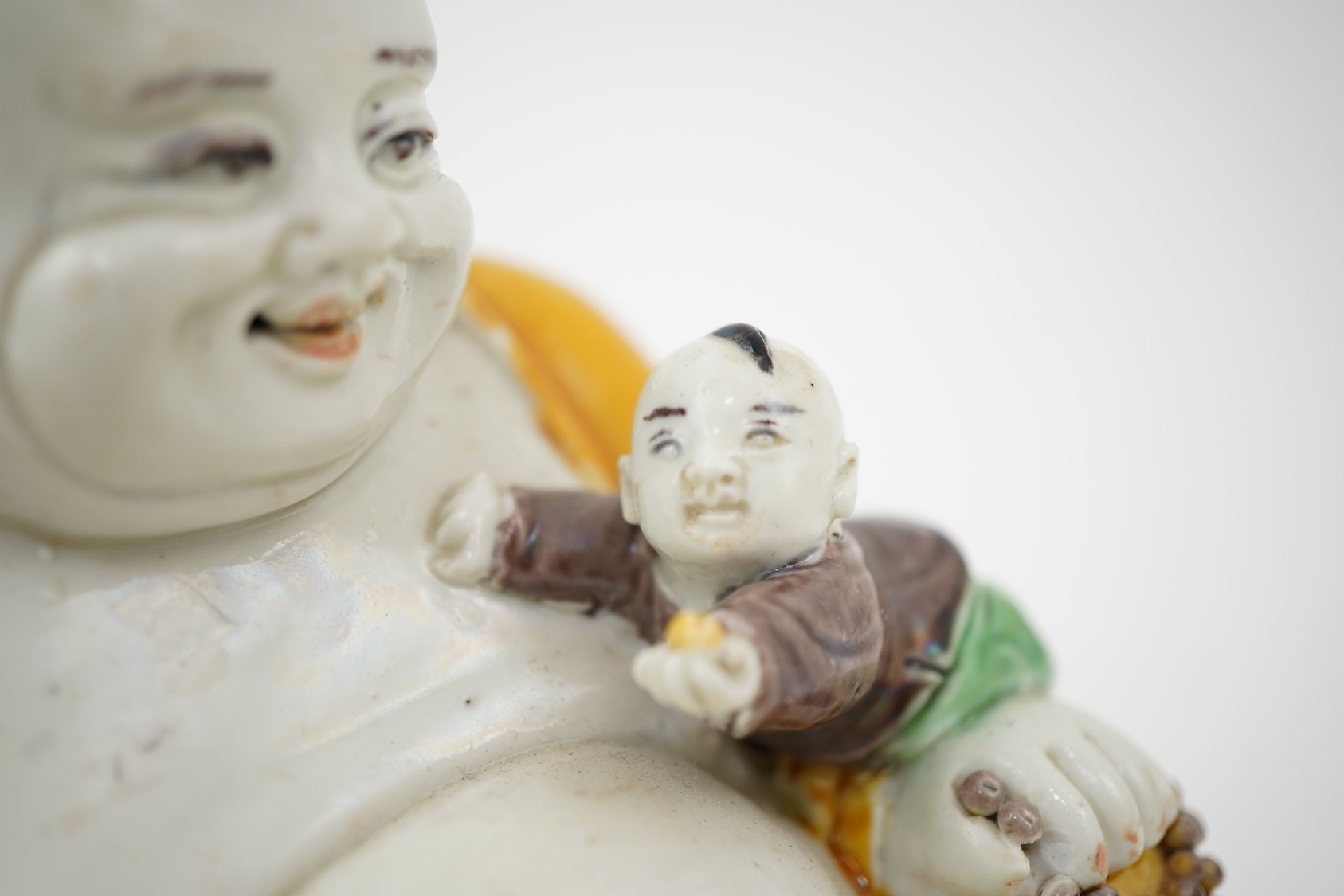 A Chinese sancai glazed biscuit group of Budai and three boys, 19th century